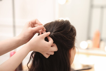 Hair styling. Professional hairdresser working with client indoors, closeupの写真素材