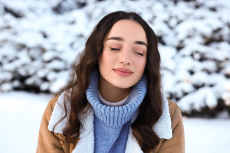 Portrait of beautiful woman in snowy parkの写真素材