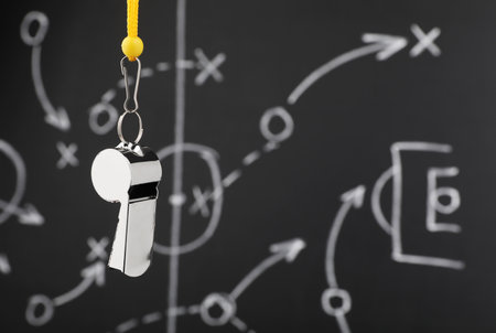 Referee whistle against chalkboard with game scheme, closeup. Space for textの写真素材