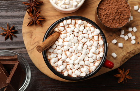 Tasty hot chocolate with marshmallows and ingredients on wooden table, flat layの写真素材