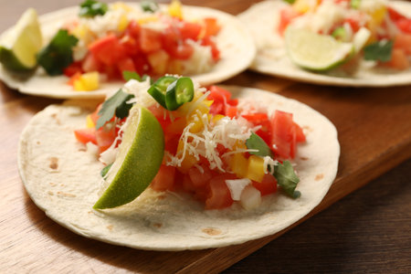 Delicious tacos with vegetables and lime on wooden table, closeupの写真素材
