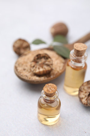 Nutmeg essential oil, whole and ground nuts on light table, closeupの写真素材