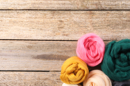 Colorful felting wool on wooden table, top view. Space for textの写真素材