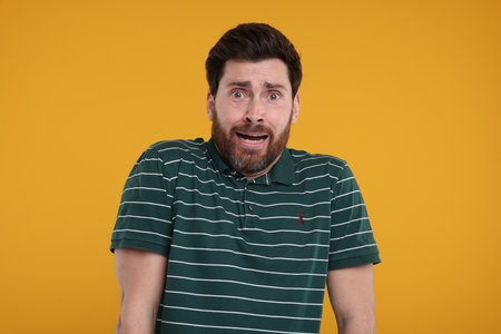 Portrait of surprised man on yellow backgroundの写真素材
