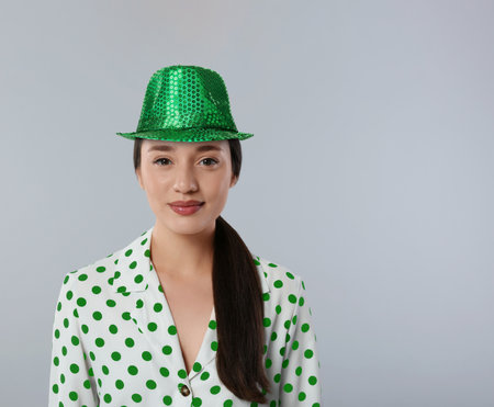 St. Patrick's day party. Pretty woman in green leprechaun hat on gray background. Space for textの写真素材
