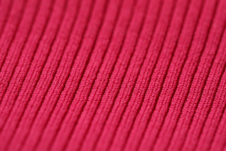 Texture of soft red knitted fabric as background, closeup