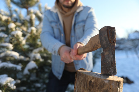 Man chopping wood with ax outdoors on winter day, closeupの写真素材