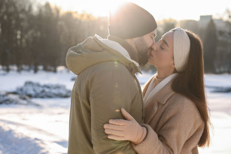 Beautiful happy couple in snowy park on winter dayの写真素材