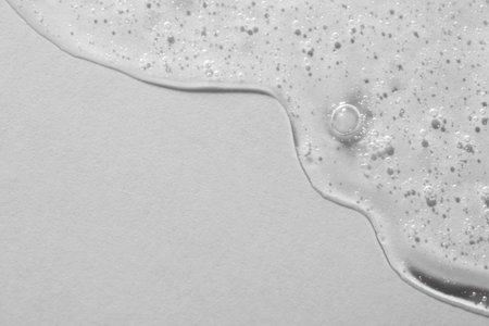 Clear cosmetic serum on light background, macro view. Space for textの写真素材