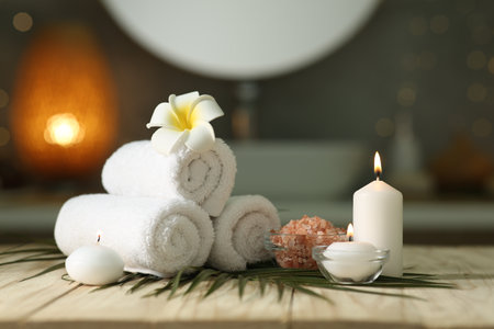 Composition with different spa products and burning candles on wooden table indoorsの写真素材