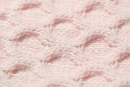 Texture of soft pink knitted fabric as background, closeup