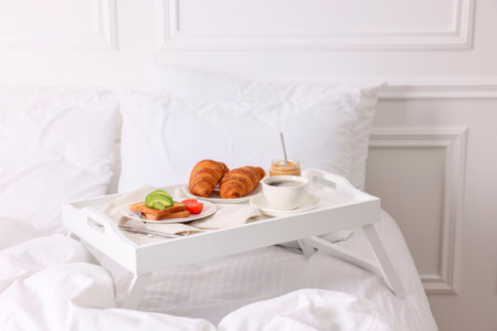 Good morning. Tray with tasty breakfast on bed at home