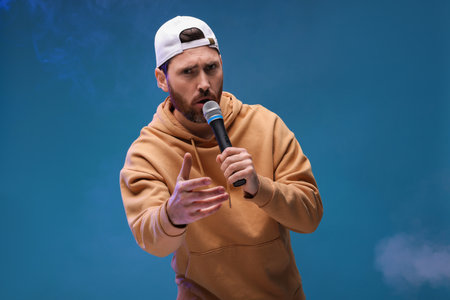 Singer with microphone rapping on blue backgroundの写真素材