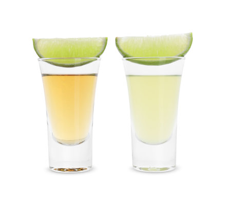 Different shooters in shot glasses and lime wedges isolated on white. Alcohol drinkの写真素材