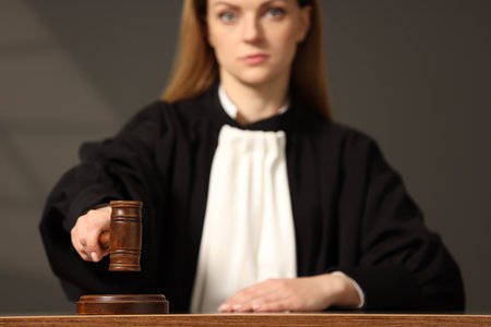 Judge striking mallet at wooden table in courtroom, selective focusの写真素材