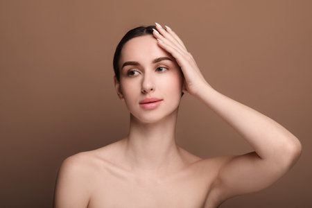 Portrait of beautiful young woman on brown backgroundの写真素材