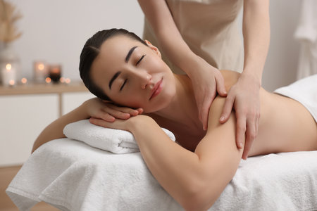 Woman receiving massage on couch in spa salonの写真素材