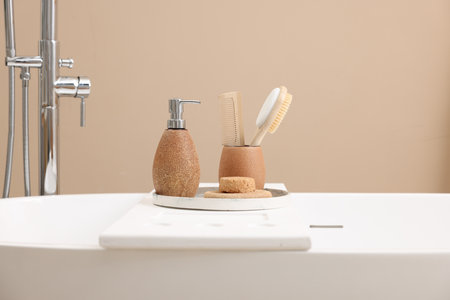 Different personal care products and accessories on bath tub in bathroom