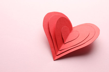 Red paper hearts on pink background. Space for textの写真素材