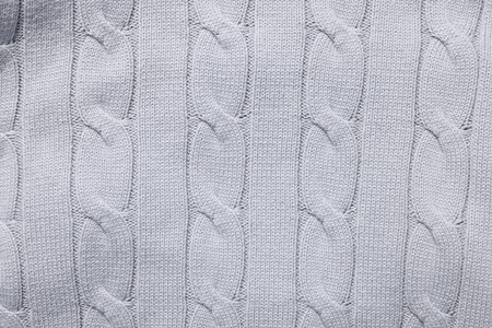 Texture of light gray knitted fabric as background, top view
