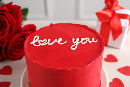 Bento cake with text Love You, roses, paper hearts and gift box on white table, closeup. St....