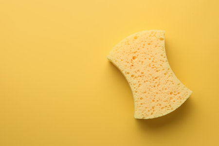 Sponge on yellow background, top view. Space for textの写真素材