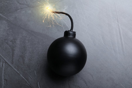 Old fashioned black bomb with lit fuse on gray table, top viewの写真素材