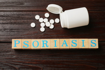 Word Psoriasis made of cubes with letters and pills on wooden table, flat layの写真素材