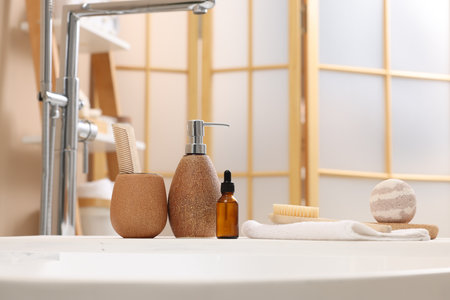 Different personal care products and accessories on bath tub in bathroomの写真素材