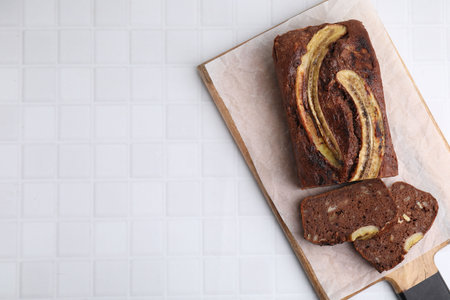 Delicious banana bread on white tiled table, top view. Space for textの写真素材