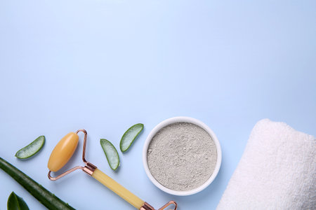 Flat lay composition with cosmetic products and cut aloe leaves on light blue background. Space for textの写真素材