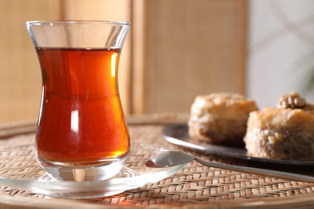 Traditional Turkish tea in glass on wicker table, closeup. Space for textの写真素材