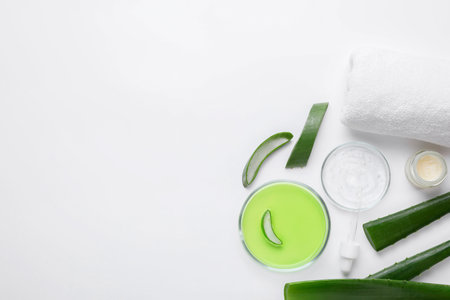 Flat lay composition with cosmetic products and cut aloe leaves on white background. Space for textの写真素材