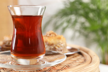 Traditional Turkish tea in glass on wicker table, closeup. Space for textの写真素材
