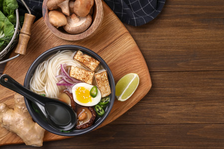 Delicious vegetarian ramen and products on wooden table, flat lay. Space for textの写真素材