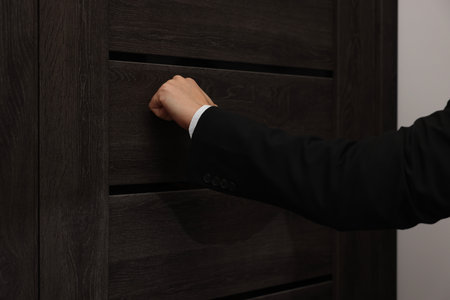 Collector knocking on door indoors, closeup viewの写真素材