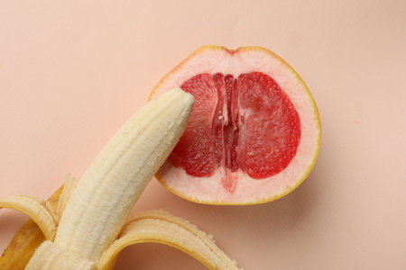Banana and half of grapefruit on beige background, top view. Sex conceptの写真素材