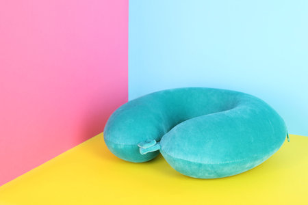 Soft turquoise travel pillow on color background, space for textの写真素材