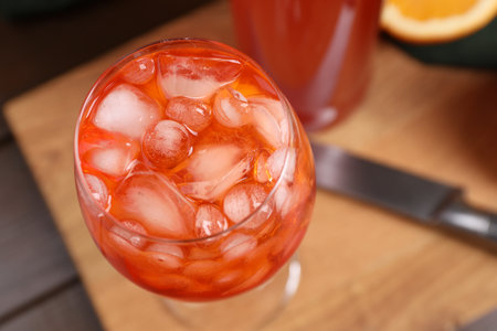 Aperol spritz cocktail and ice cubes in glass on wooden table, above viewの写真素材