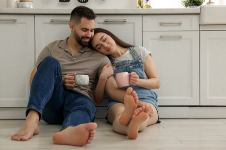 Affectionate young couple spending time together in kitchen. Space for textの写真素材