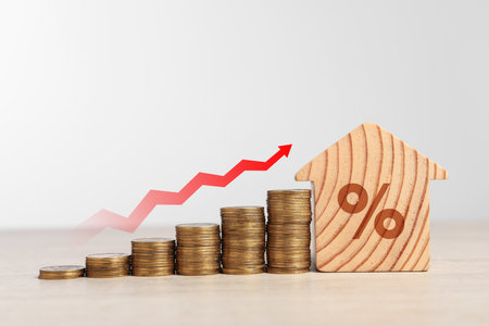 Mortgage rate. Stacked coins, arrow and wooden model of house with percent signの写真素材