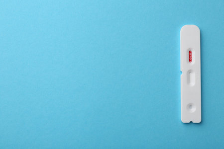 Disposable Covid-19 express test on light blue background, top view. Space for text
