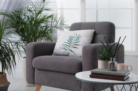 Soft pillow with printed tropical leaf on armchair indoorsの写真素材