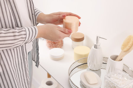 Bath accessories. Woman with jar of cosmetic product indoors, closeupの写真素材