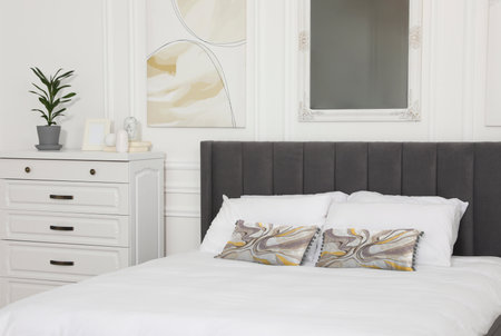 Soft pillows with stylish abstract prints on bed indoors