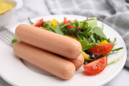 Delicious boiled sausages with salad on table, closeupの写真素材
