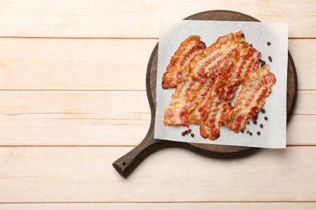 Delicious fried bacon slices on white wooden table, top view. Space for textの写真素材