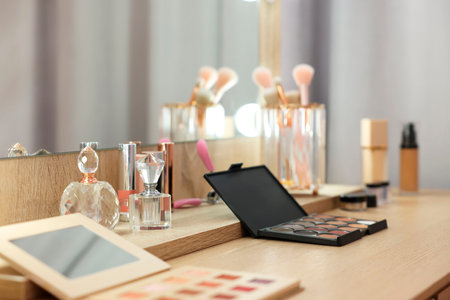 Cosmetic products and perfumes on wooden dressing table in makeup roomの写真素材