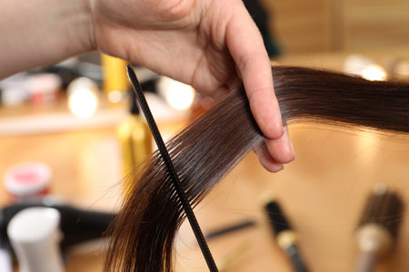 Hairdresser combing client's hair in salon, closeupの写真素材