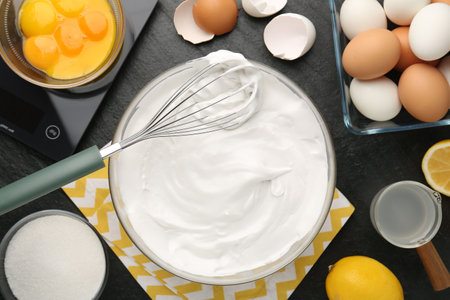 Bowl with whipped cream, whiskey and ingredients on black table, flat layの写真素材